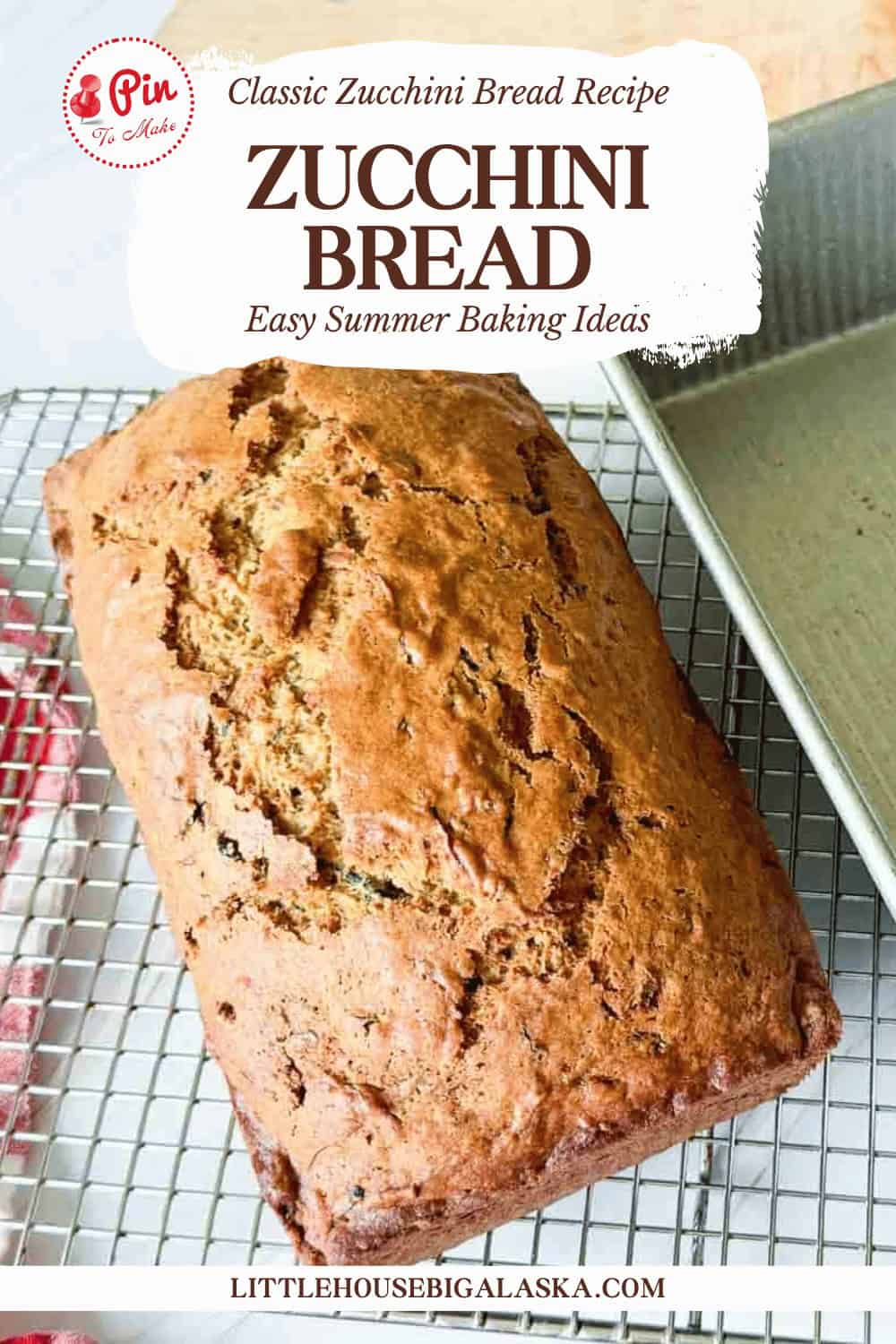 A fresh loaf of zucchini bread sits on a wire cooling rack next to a metal baking pan. Text on the image highlights a classic zucchini bread recipe from Little House Big Alaska.