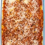 A glass baking dish filled with baked lasagna, topped with melted cheese and visible layers of meat sauce, reminiscent of a comforting Million Dollar Spaghetti casserole.