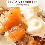 Close-up of slow cooker pecan cobbler topped with a scoop of vanilla ice cream on a white plate, with a fork and the gooey, caramelized filling of the slow cooker pecan cobbler clearly visible.
