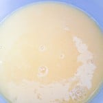 A light yellow liquid with small bubbles in a blue bowl.